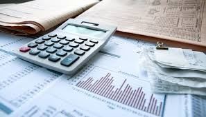 A calculator sitting on a pile of files.