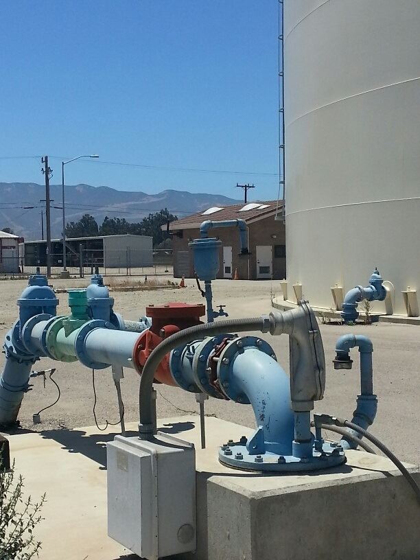 A water pipe with a large water tank in the background.