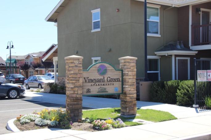 A sign in front of an apartment building.