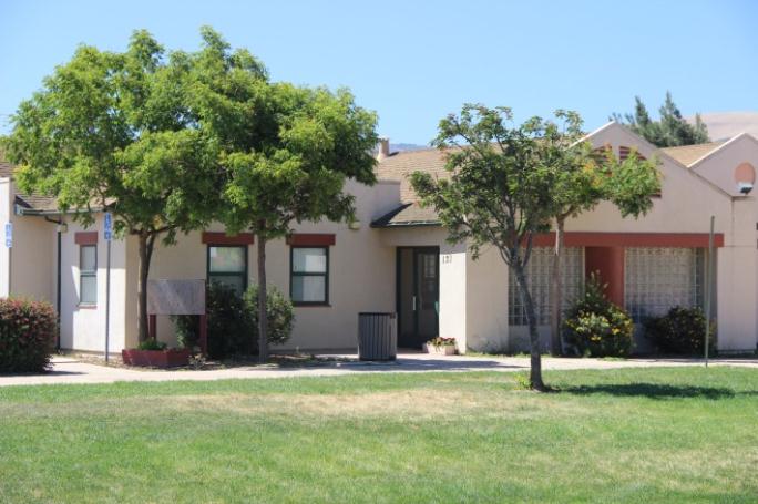 The building for the Mexican American Opportunity Foundation. A white building with trees and bushed
