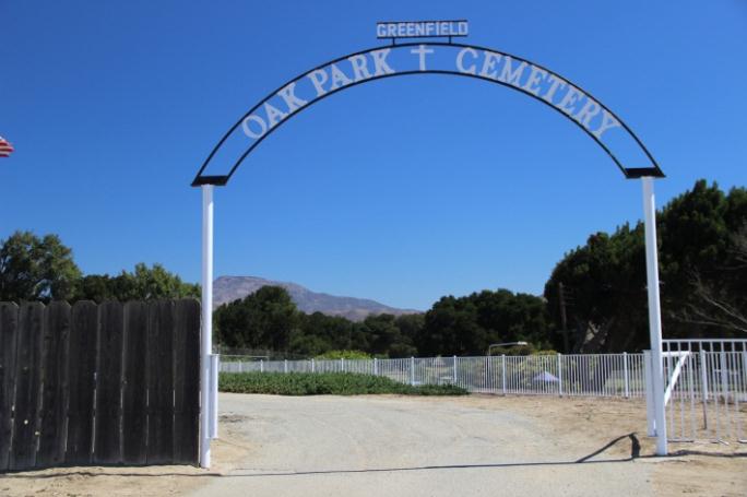 The entrance to the cemetery. A large white sign shaped like an arch.