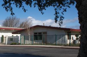 A small white building with a red roof.