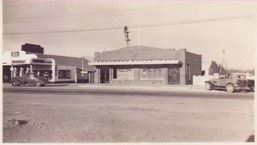 A black and white photo of a row of businesses.